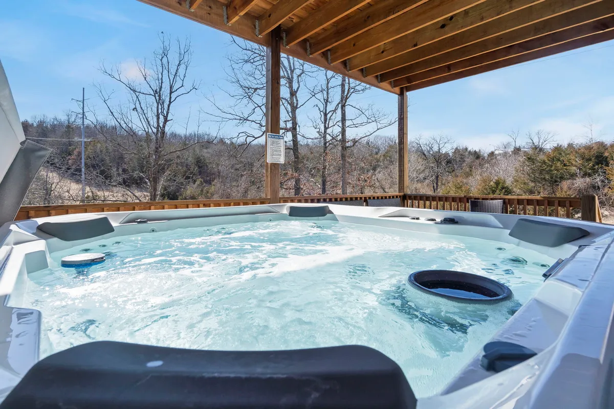 A private hot tub nestled on a wooden deck surrounded by tall trees, offering a serene atmosphere for relaxing soaks. The scene evokes feelings of privacy, peace, and immersion in nature—especially under the night sky.
