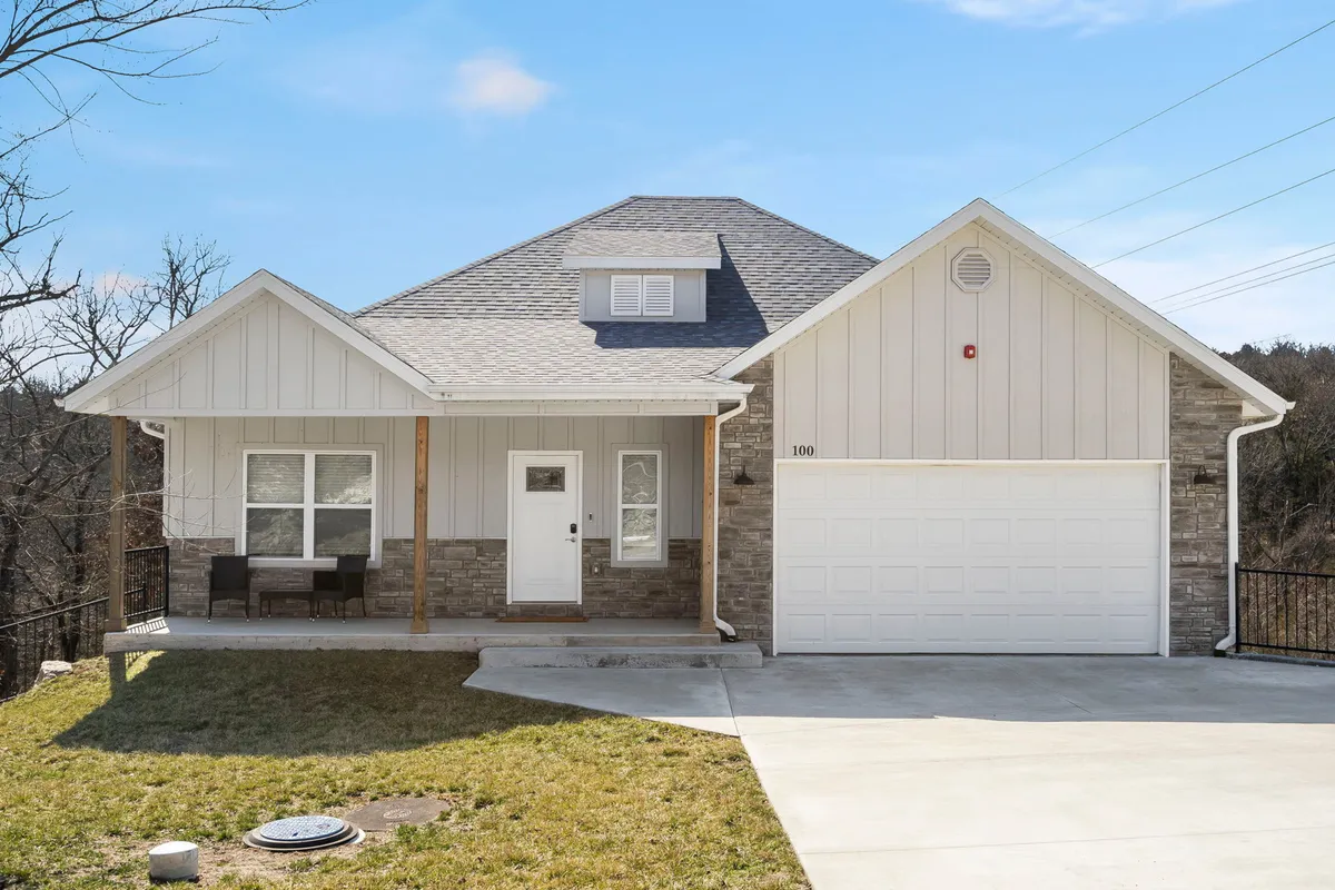 A welcoming exterior shot of a home with a spacious front porch, a landscaped lawn, and a visible garage door. The scene conveys easy access to the outdoors and the neighborhood, hinting at the property's proximity to local attractions and inviting guests to step out for adventure.